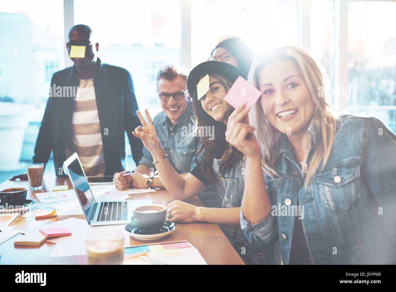 Équipe diversifiée d'employés de bureaux, hommes et femmes jouant avec les notes au tableau Banque D'Images