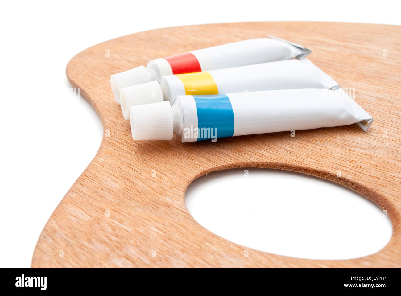 Une palette de l'artiste traditionnel en bois avec des tubes de peinture dans des couleurs primaires. Isolé sur fond blanc. Ombres douces retaine. Banque D'Images