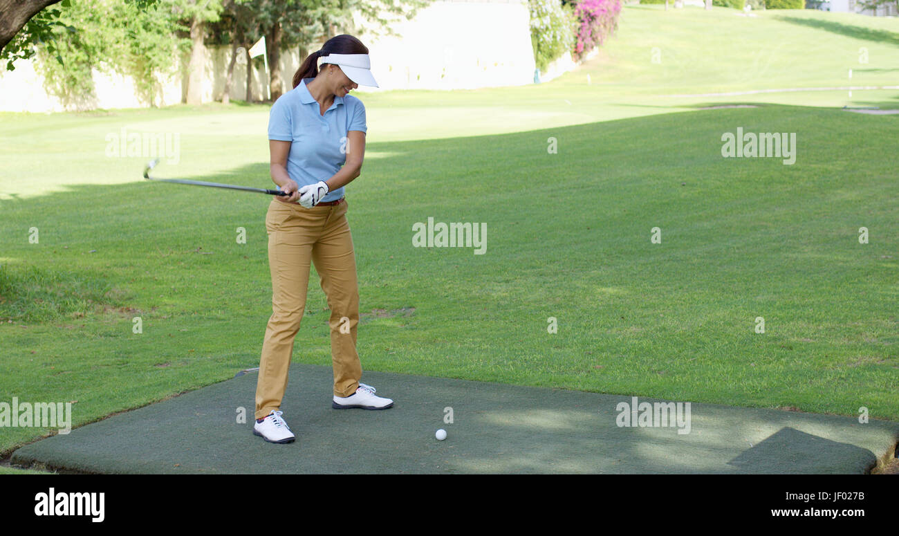 Jeune golfeuse prépare à tee off Banque D'Images