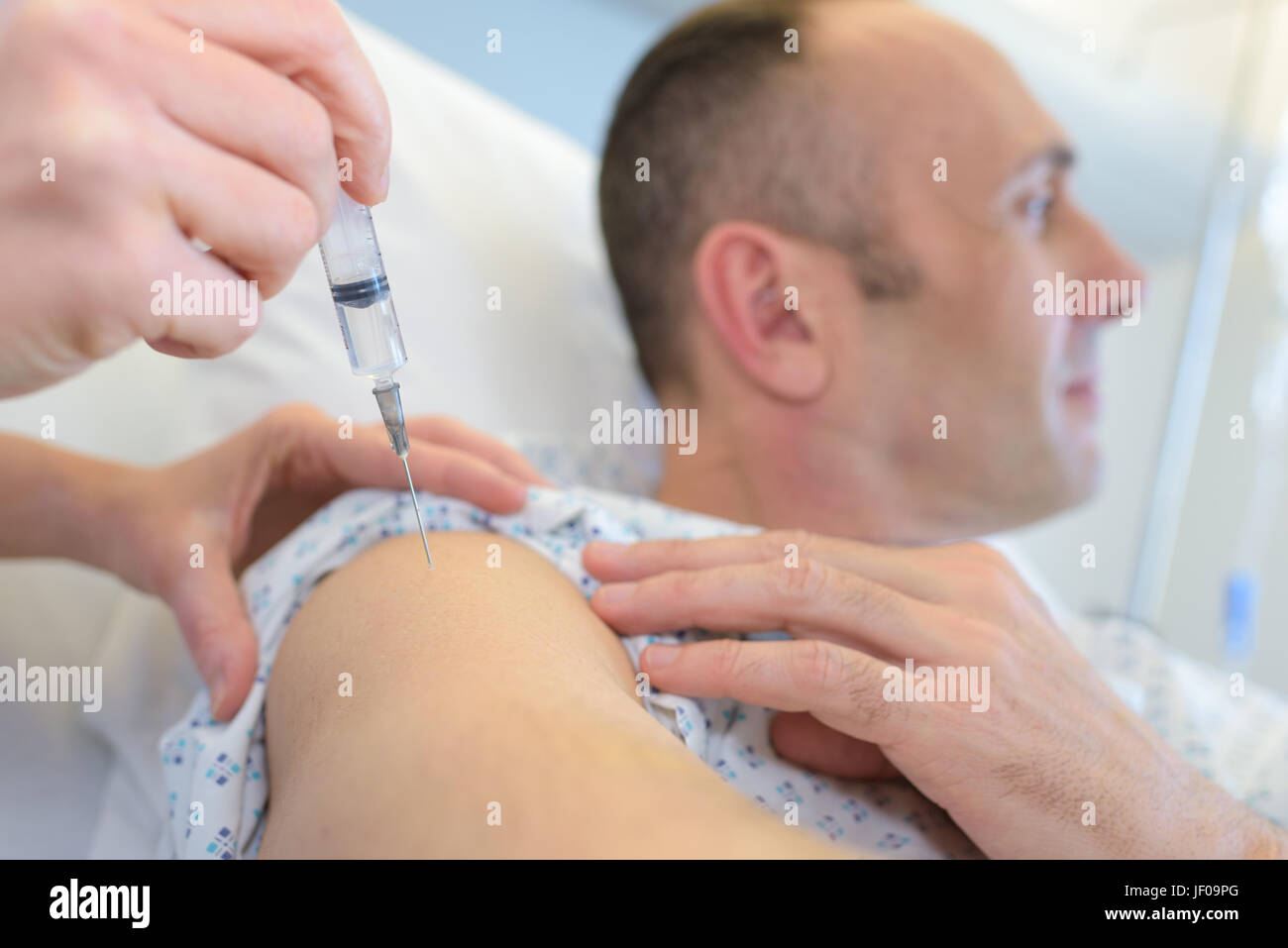 L'homme à la voiture tout en ayant l'injection dans le bras Banque D'Images