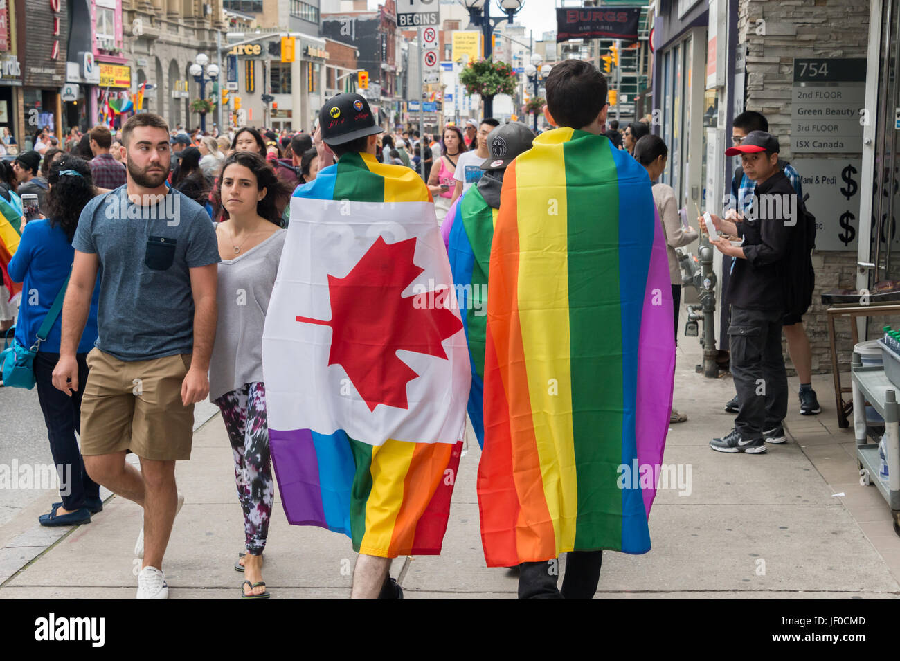 Toronto, CA - 25 juin 2017 : deux hommes avec drapeau gay arc-en-ciel sur le dos vont à Toronto Gay Pride Parade. Banque D'Images