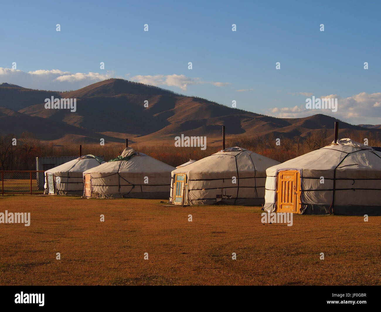 Le coucher du soleil chaud allume le gers mongole traditionnelle dans la steppe en dehors de Oulan-bator Banque D'Images