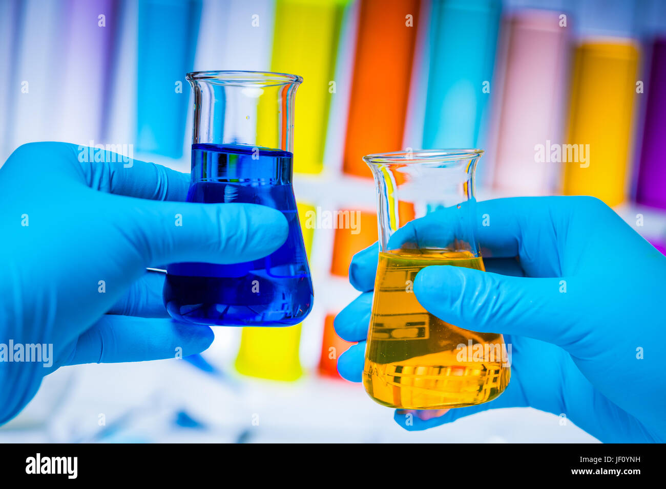 Technicien compare deux flacons de substances colorées dans un laboratoire. La science de la chimie et de l'équipement. Banque D'Images