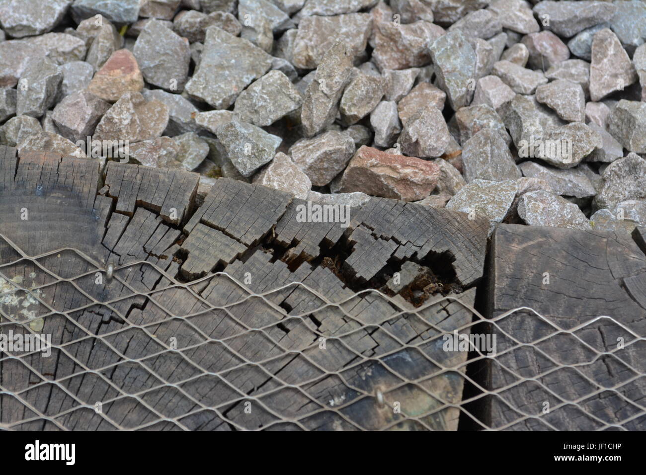 La pourriture du bois en bois patiné decay in garden railway sleeper re traitement de bois pourri avec galets de forme irrégulière de toucher Banque D'Images