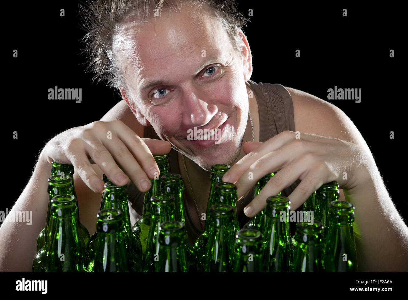 L'homme éméché heureux près de bouteilles de bière vides Banque D'Images