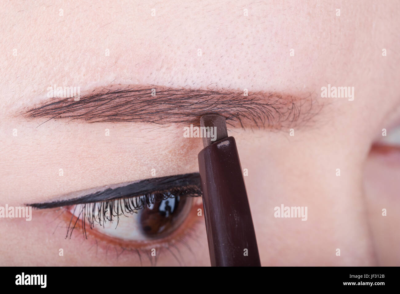 Close-up à l'aide de maquillage crayon sourcil femme Banque D'Images