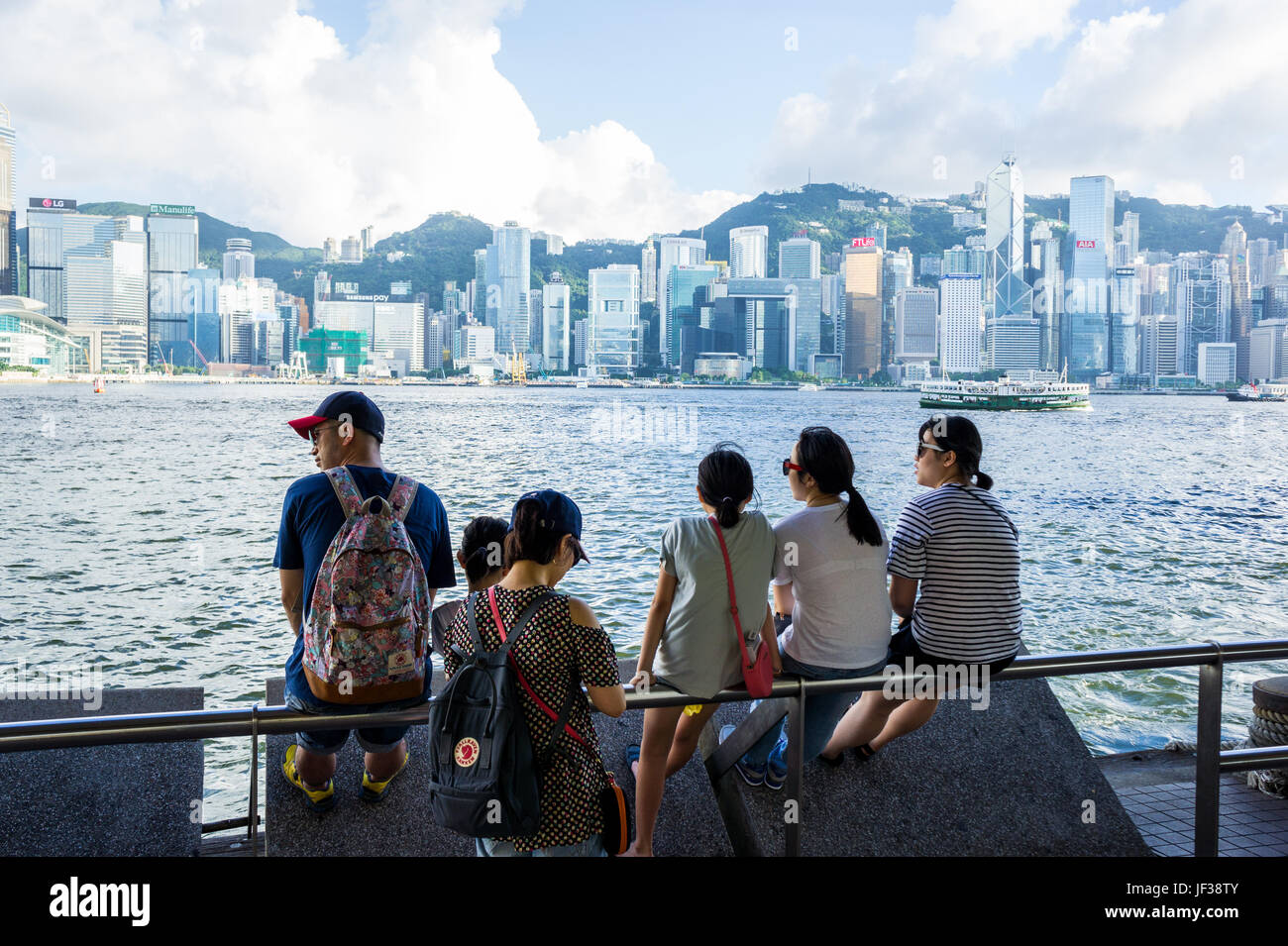 Les touristes asiatiques portant des lunettes de soleil et le regard sur le port de Hong Kong harbor skyline Banque D'Images