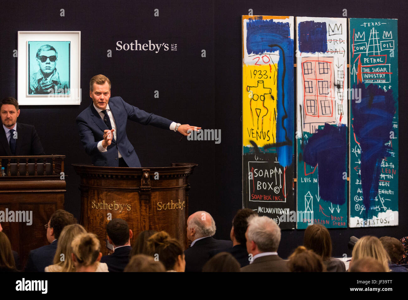 Londres, Royaume-Uni. 28 juin 2017. Commissaire-priseur Oliver Barker fielding offres à l'avant de l'œuvre d'Andy Warhol Autoportrait, 1963-1964, qui a vendu pour 6 008 750 GBP et Jean-Michel Basquiat Untitled de peinture, 1983, qui a vendu pour 6 492 500 GBP. Soirée d'art contemporain de Sotheby's Vente aux enchères a lieu à leurs nouveaux locaux de Bond Street. Banque D'Images