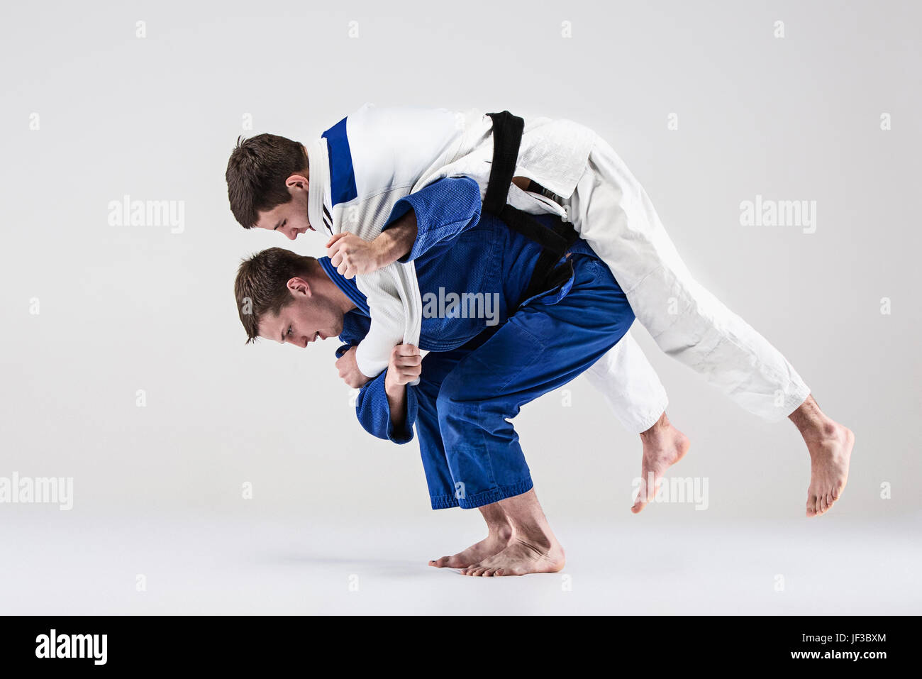 Les deux combattants judokas combattants gris sur fond de studio Banque D'Images