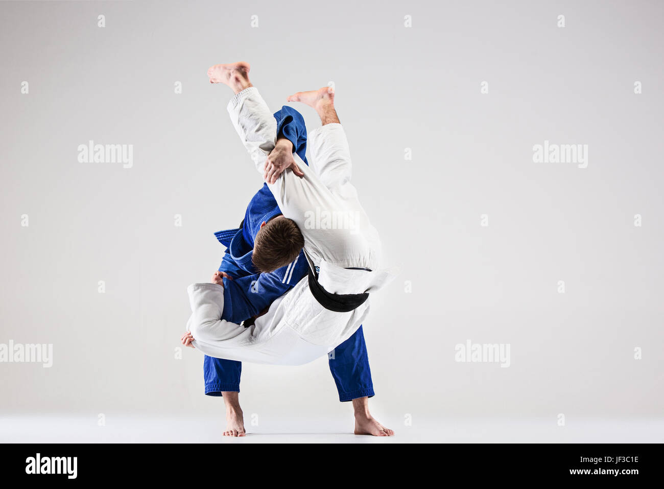 Les deux combattants judokas combattants gris sur fond de studio Banque D'Images