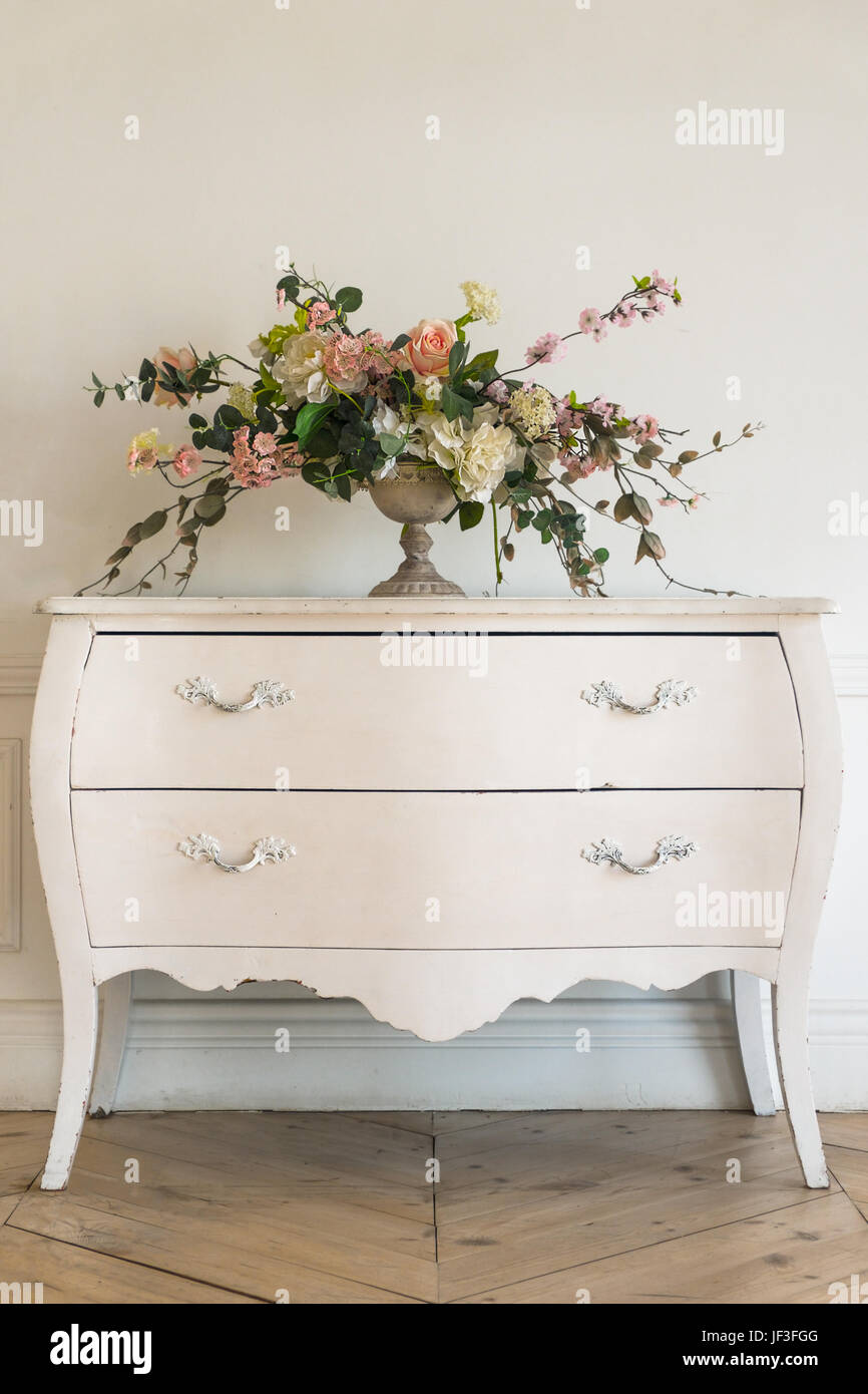Commode vintage avec les fleurs dans le luxe de l'intérieur blanc brillant Banque D'Images