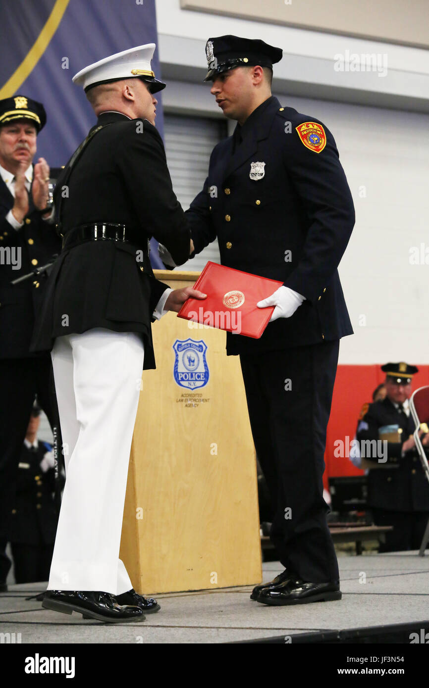 Agent de police du comté de Suffolk Matias Ferreira reçoit un certificat de mention élogieuse de marine Le Capitaine Jon Stange, le directeur général pour le recrutement du Corps des Marines Station New York, au cours d'une cérémonie de remise de prix à la Suffolk County Community College le 24 mars 2017, à Brentwood, N.Y. Ferreira a été reconnu par le commandant de la Marine Corps pour les sacrifices consentis et de l'engagement affiché par Ferreira pendant son temps comme aire marine et depuis son départ de la classe active. Le commandant dit Ferreira illustre les valeurs et l'éthique du Marine Corps. Banque D'Images