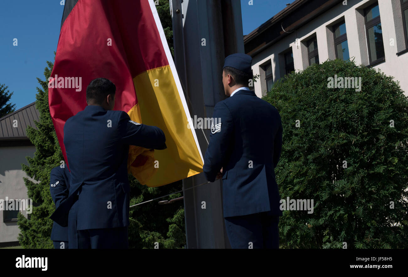 Les aviateurs de l'US Air Force affectée à la 86e Groupe d'opérations d'abaisser le drapeau allemand au cours d'une cérémonie commémorative en retraite sur base aérienne de Ramstein, en Allemagne, le 26 mai 2017. Memorial Day a commencé comme un jour de rendre hommage à des soldats de l'Union la guerre civile américaine, mais a été étendue à tous les hommes et femmes qui sont morts dans une guerre ou une action militaire après la Première Guerre mondiale (U.S Air Force photo de l'Aviateur de Tryphena Senior Mayhugh) Banque D'Images