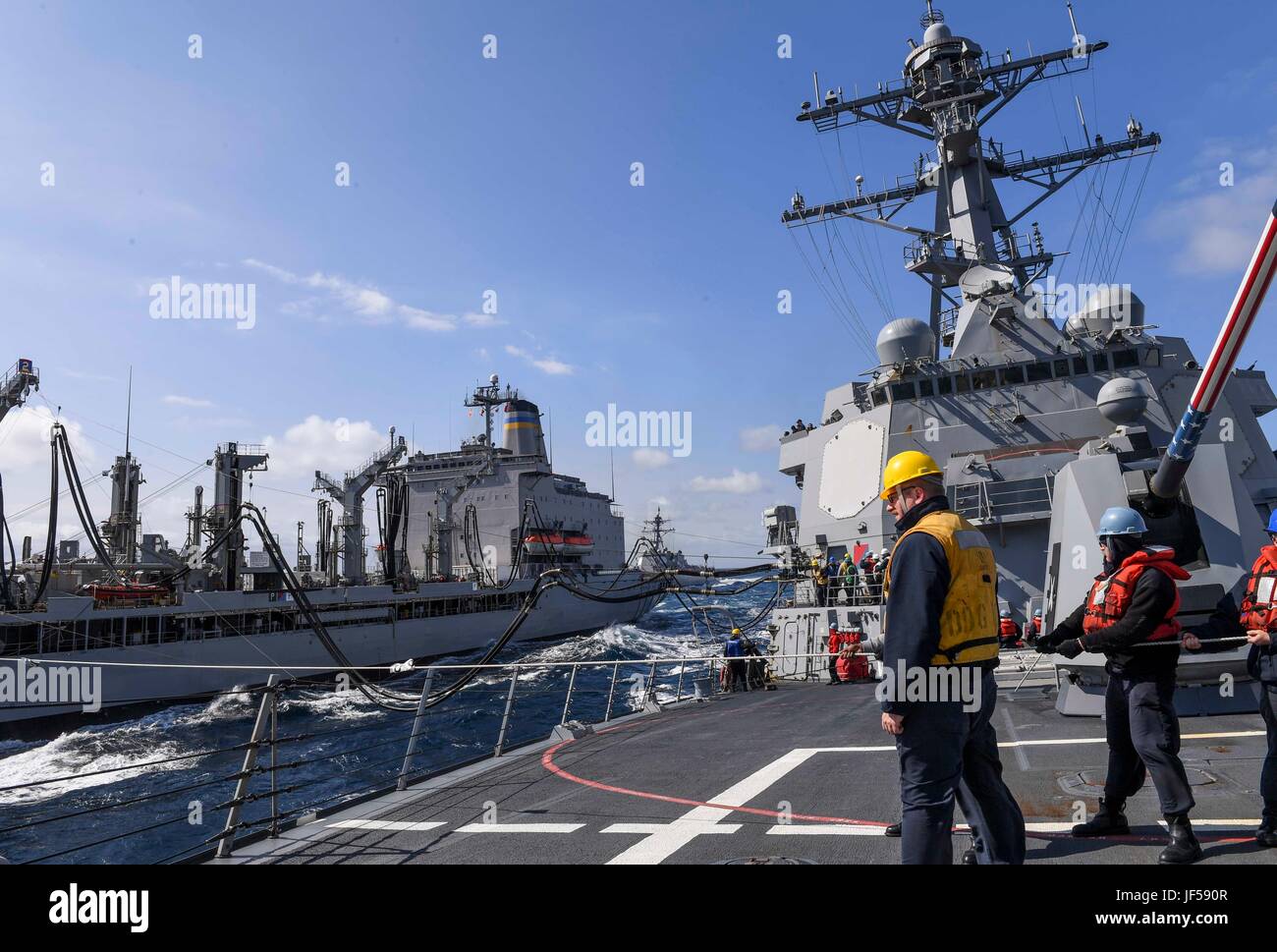 170526-N-RM689-195 PACIFIQUE OUEST (26 mai 2017) Les marins à bord de la classe Arleigh Burke destroyer lance-missiles USS Wayne E. Meyer (DDG 108) conduite d'un ravitaillement en mer avec l'USNS lubrificateur reconstitution de la flotte (Marshalltown T-AO 204) comme la classe Arleigh Burke destroyer lance-missiles USS Mustin (DDG 89) fait son approche. La Marine américaine a patrouillé les Indo-Asia-Pacifique couramment pour plus de 70 ans la promotion de la paix et la sécurité régionales. (U.S. Photo par marine Spécialiste de la communication de masse 3 Classe Kelsey L. Adams/libérés) Banque D'Images