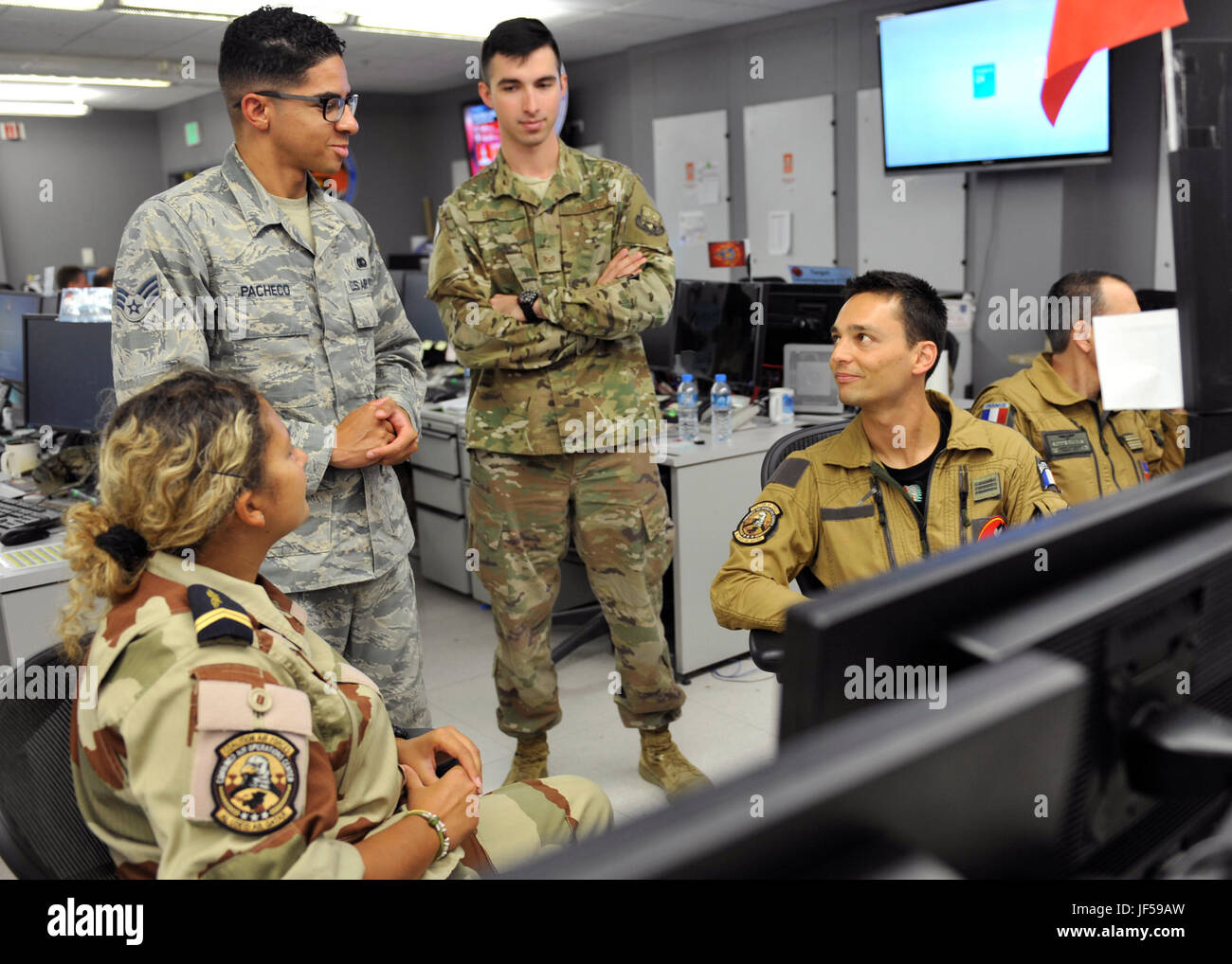 Les membres de l'armée de l'air française parlent avec des aviateurs dans le centre d'opérations aériennes combinées, le 27 mai 2017, à Al Udeid Air Base, au Qatar. Le CMOA est composé de membres de la coalition qui le quart-arrière des opérations aériennes dans 24 heures sur 24, la zone de responsabilité du Commandement central. (U.S. Photo de l'Armée de l'air par le sergent. Desiree Economides) Banque D'Images
