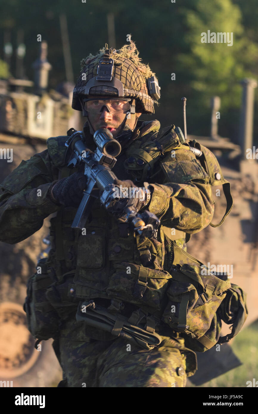 Un militaire canadien, 1er Bataillon du Royal Canadian Regiment, de la Compagnie Bravo, tactiquement se déplace pour aider à dégager un village tenu par le 1er Bataillon du Royal Canadian Regiment, de la Compagnie Bravo, au cours d'une bataille simulée dans l'exercice Maple résoudre 17 au Camp Wainwright en Alberta, Canada, le 28 mai 2017. L'exercice Maple Resolve est un événement annuel de formation collective conçue pour toute opération d'urgence. Environ 4 000 et 1 000 membres du service canadien de la Compagnie aux États-Unis, Grande-Bretagne, Australie, Nouvelle-Zélande, et la France participent à l'exercice de cette année. (U.S. Photo de la Garde nationale par la CPS. Elizabeth Sco Banque D'Images