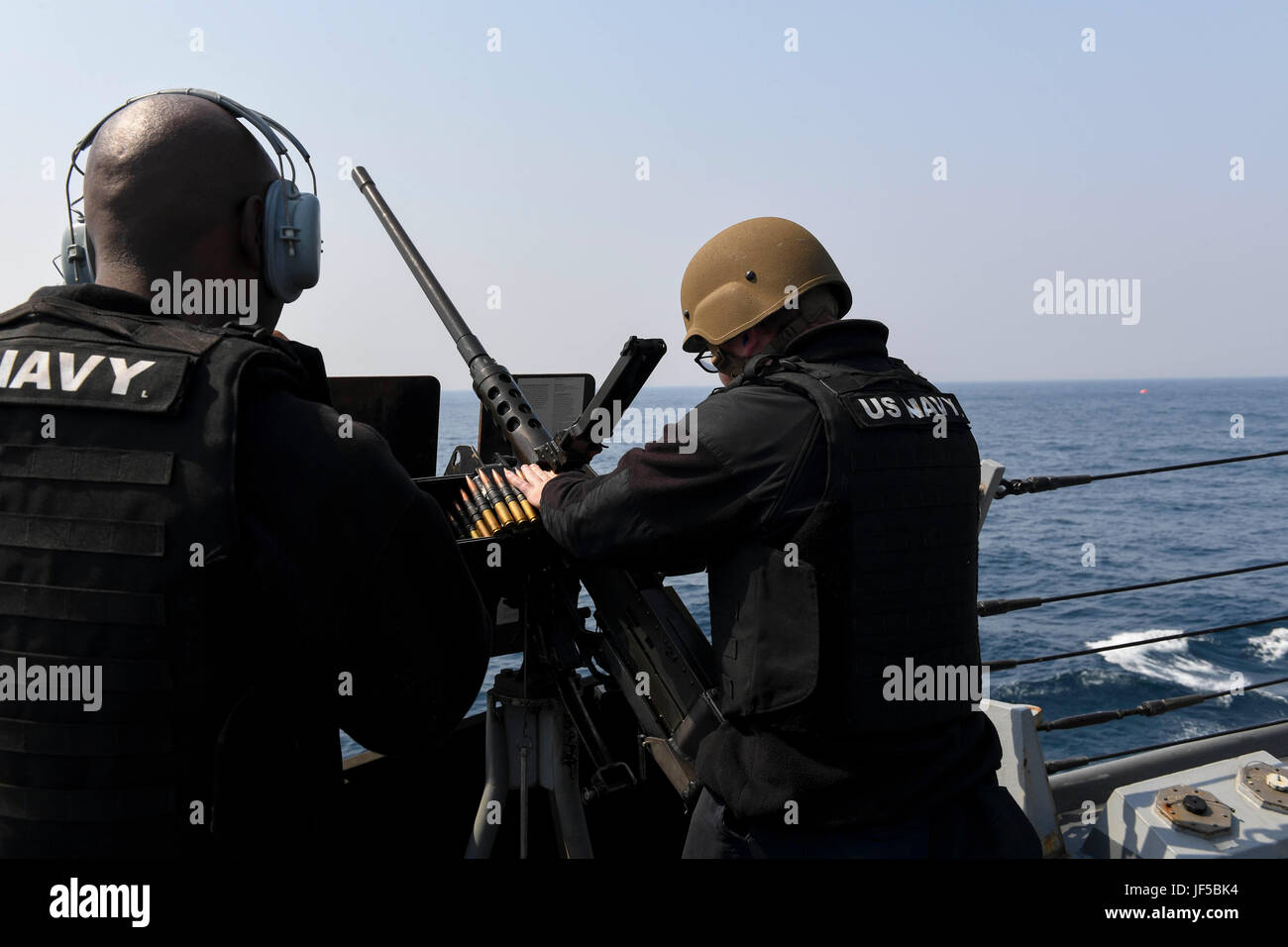 170529-N-RM689-360 PACIFIQUE OUEST (29 mai 2017) 3ème classe Technicien en électronique Joshua Bullock (à droite), de Klamath Falls, Oregon, charges de munitions sur une mitrailleuse de calibre .50 comme spécialiste des questions de personnel 2e classe Luxon Molina, de Lauderhill, Fla., agit comme un automate vocal téléphone au cours d'un exercice de tir réel à bord de la classe Arleigh Burke destroyer lance-missiles USS Wayne E. Meyer (DDG 108). La Marine américaine a patrouillé les Indo-Asia régulièrement du Pacifique pendant plus de 70 ans la promotion de la paix et la sécurité régionales. (U.S. Photo par marine Spécialiste de la communication de masse 3 Classe Kelsey L. Adams/libérés) Banque D'Images