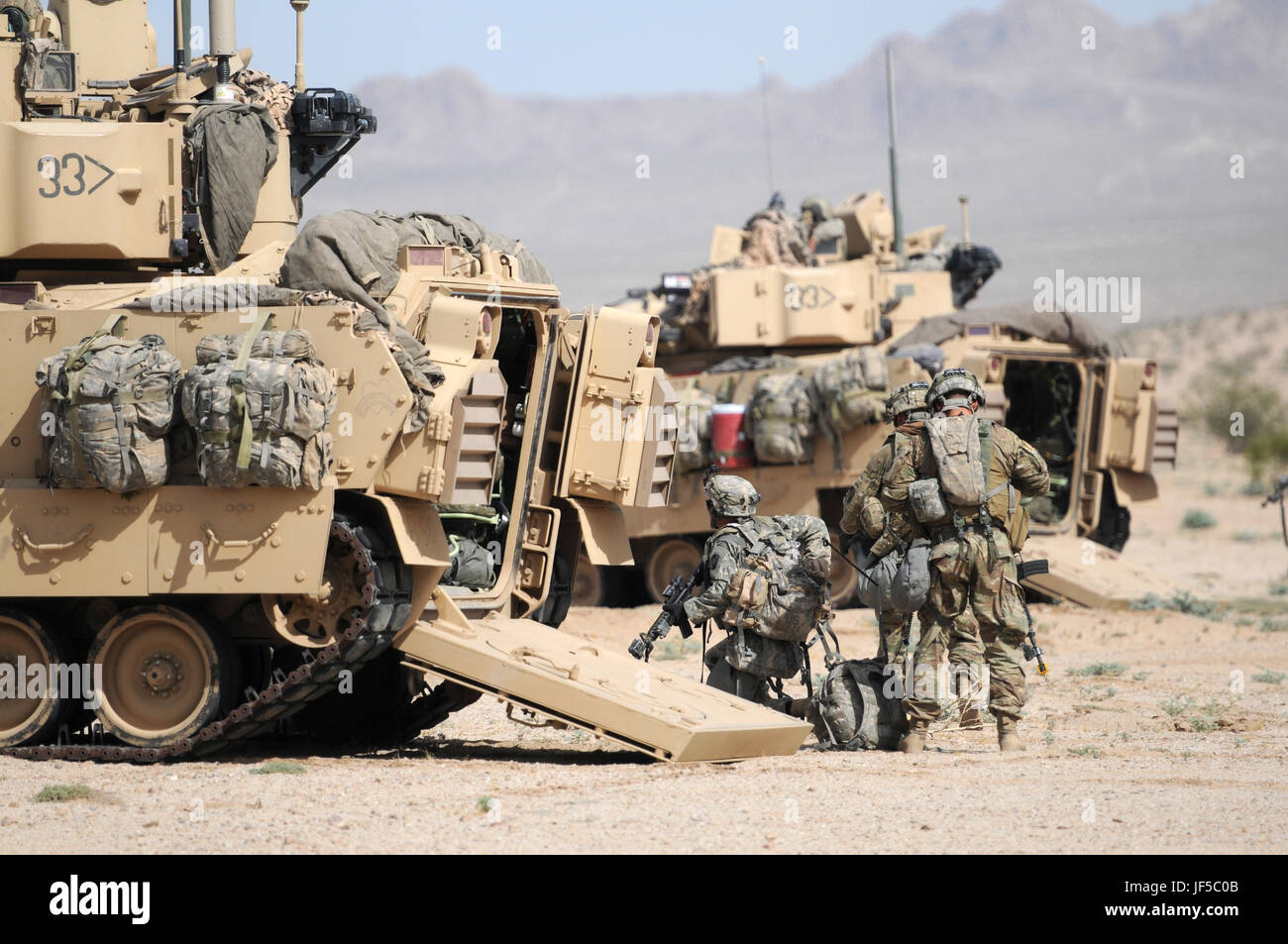 Des soldats de l'équipe de combat de la 155e brigade blindée descendent d'un véhicule de combat Bradley lors d'un exercice d'armes combinées au National Training Center, Fort Irwin, Californie, le 30 mai 2017, atteindre leur objectif dans le cadre d'opérations de formation coordonnées. Banque D'Images