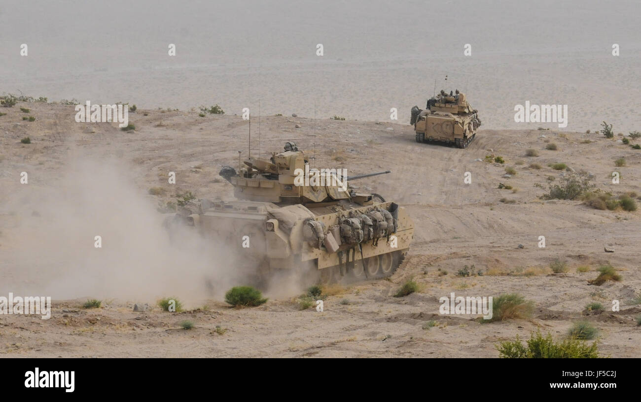 Les véhicules de combat Bradley avancent à travers le désert lors d'un exercice force-force au National Training Center, Fort Irwin, dans le cadre de la rotation de l'équipe de combat de la 155e brigade blindée, simulant des opérations de combat. Banque D'Images