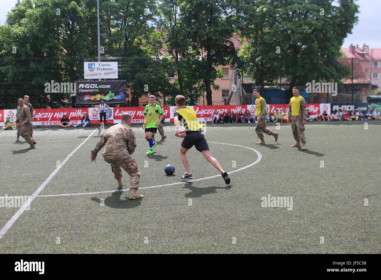 Pologne Groupe de combat des soldats américains en compétition dans un match de football avec les élèves d'une école locale de Wydminy, la Pologne au cours de l'OTAN de l'école Jours de l'événement le 30 mai . Le groupement tactique est en Pologne dans le cadre de l'OTAN et de la présence accrue de l'avant les États-Unis, le Royaume-Uni et les soldats roumains de l'unité multinationale ont été très actif avec les communautés voisines tout comme un moyen de rendre les citoyens conscients de leur présence et d'en apprendre davantage sur la mission du groupe de combat. (U.S. Photo de l'armée par le Sgt. Jimmy Golden /libéré) Banque D'Images