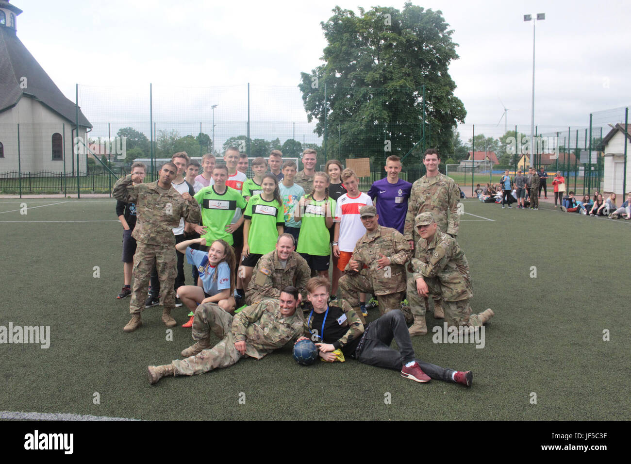 Pologne Groupe de combat des soldats américains posent avec des étudiants d'une école locale de Wydminy, Pologne après un match de football au cours de l'OTAN de l'école Jours de l'événement le 30 mai . Le groupement tactique est en Pologne dans le cadre de l'OTAN et de la présence accrue de l'avant les États-Unis, le Royaume-Uni et les soldats roumains de l'unité multinationale ont été très actif avec les communautés voisines tout comme un moyen de rendre les citoyens conscients de leur présence et d'en apprendre davantage sur la mission du groupe de combat. (U.S. Photo de l'armée par le Sgt. Jimmy Golden /libéré) Banque D'Images