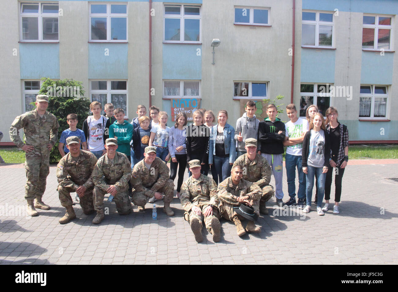 Pologne Groupe de combat des soldats américains posent avec des étudiants d'une école locale de Wydminy, la Pologne au cours de l'OTAN de l'école Jours de l'événement le 30 mai . Le groupement tactique est en Pologne dans le cadre de l'OTAN et de la présence accrue de l'avant les États-Unis, le Royaume-Uni et les soldats roumains de l'unité multinationale ont été très actif avec les communautés voisines tout comme un moyen de rendre les citoyens conscients de leur présence et d'en apprendre davantage sur la mission du groupe de combat. (U.S. Photo de l'armée par le Sgt. Jimmy Golden /libéré) Banque D'Images