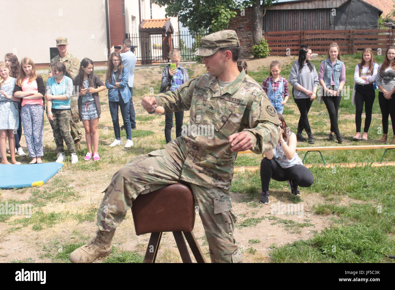 Pologne Groupe de combat des soldats américains en concurrence dans un oeuf faire relais avec les élèves d'une école locale de Wydminy, la Pologne au cours de l'OTAN de l'école Jours de l'événement le 30 mai . Le groupement tactique est en Pologne dans le cadre de l'OTAN et de la présence accrue de l'avant les États-Unis, le Royaume-Uni et les soldats roumains de l'unité multinationale ont été très actif avec les communautés voisines tout comme un moyen de rendre les citoyens conscients de leur présence et d'en apprendre davantage sur la mission du groupe de combat. (U.S. Photo de l'armée par le Sgt. Jimmy Golden /libéré) Banque D'Images