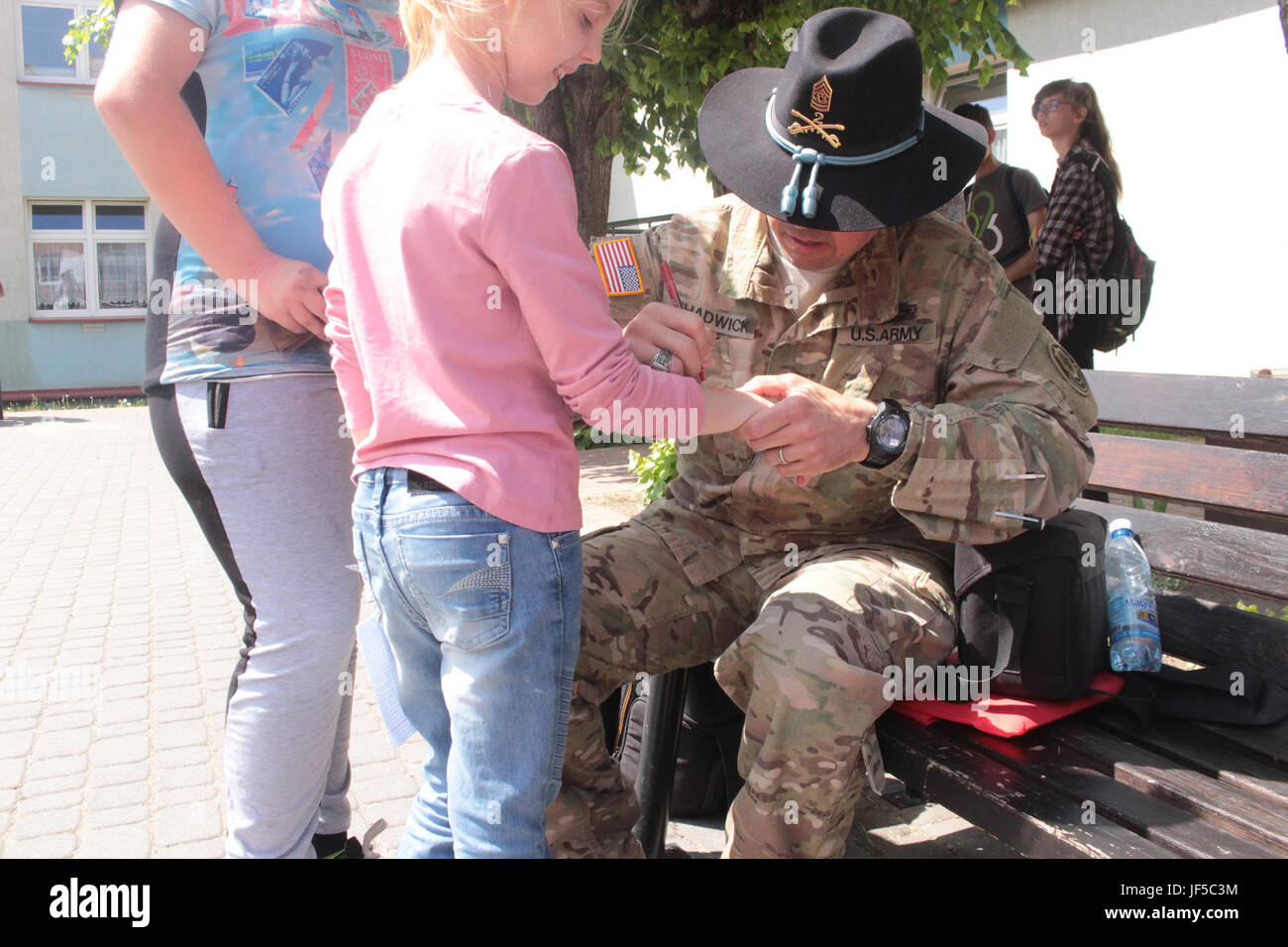 Pologne Groupe de combat de sergent-major de commandement Joe Chadwick, signe des autographes pour les étudiants d'une école locale de Wydminy, la Pologne au cours de l'OTAN de l'école Jours de l'événement le 30 mai . Le groupement tactique est en Pologne dans le cadre de l'OTAN et de la présence accrue de l'avant les États-Unis, le Royaume-Uni et les soldats roumains de l'unité multinationale ont été très actif avec les communautés voisines tout comme un moyen de rendre les citoyens conscients de leur présence et d'en apprendre davantage sur la mission du groupe de combat. (U.S. Photo de l'armée par le Sgt. Jimmy Golden /libéré) Banque D'Images