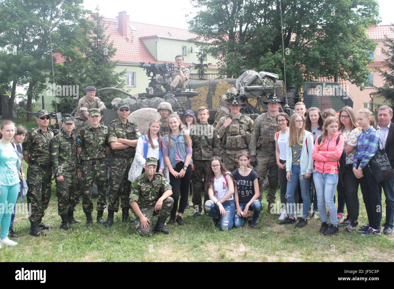 Battle Group Pologne États-Unis, Royaume-Uni et soldats roumains posent avec les élèves d'une école locale de Wydminy, la Pologne au cours de l'OTAN de l'école Jours de l'événement le 30 mai . Le groupement tactique est en Pologne dans le cadre de l'OTAN et de la présence accrue de l'avant les États-Unis, le Royaume-Uni et les soldats roumains de l'unité multinationale ont été très actif avec les communautés voisines tout comme un moyen de rendre les citoyens conscients de leur présence et d'en apprendre davantage sur la mission du groupe de combat. (U.S. Photo de l'armée par le Sgt. Jimmy Golden /libéré) Banque D'Images