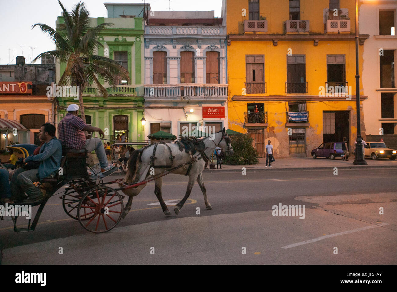 Au crépuscule, un cheval et un chariot emmènent les passagers le long des rues de La Havane. Banque D'Images