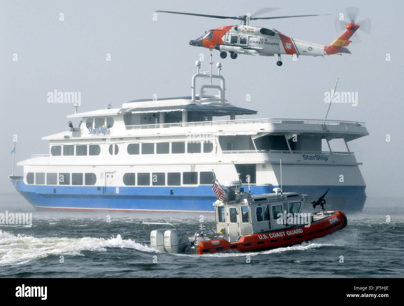 TAMPA, FLORIDE (16 août 2000 1, 2006) -- une sécurité intérieure de la Garde côtière Station de bateau Saint Petersburg, Floride, établit une zone de sécurité autour du bateau de croisière alors que StarShip un hélicoptère de la Garde côtière à partir de la Air Station de Clearwater, Floride, plane au-dessus de la tête avec un FBI conjointe et de la Garde côtière de l'équipe d'embarquement à bord. Le navire de croisière jouait un navire à moteur transportant des cargaisons dangereuses qui tentent d'entrer dans le port avec un présumé terroriste à bord durant 2006. Sentinel Bay L'équipe d'abordage est préparation de l'abaissement de l'hélicoptère et recherche de la personne soupçonnée de terrorisme. Bay Sentinel est un objectif de l'exercice Banque D'Images