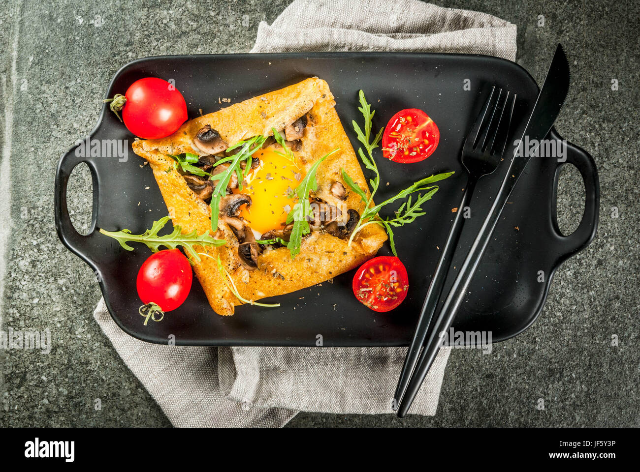 La cuisine française. Le petit-déjeuner, déjeuner et collations. La nourriture végétalienne. Galette au sarrasin plat traditionnel. Crêpes avec œufs, fromage, champignons frits, roquette et Banque D'Images