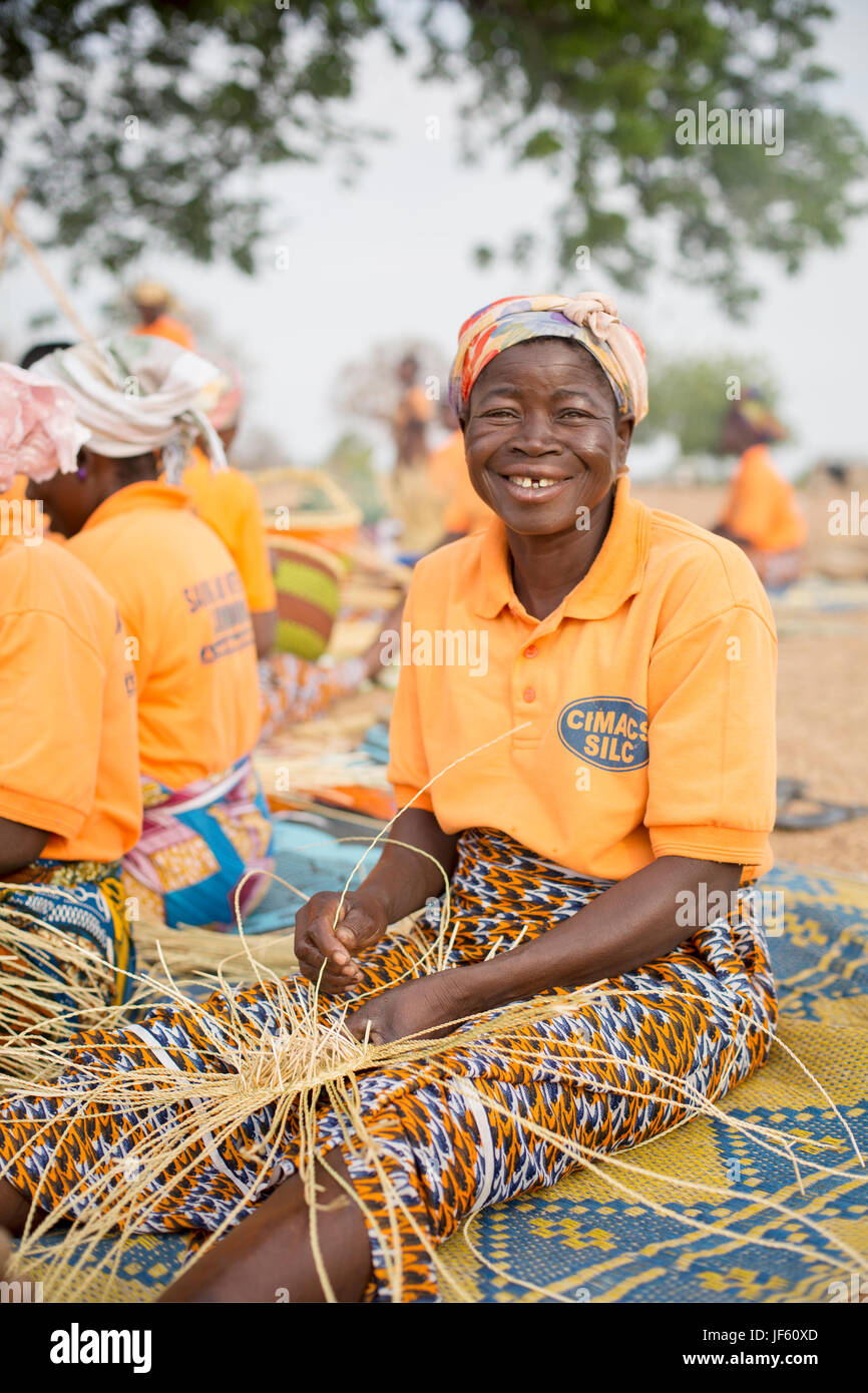 Les femmes d'une coopérative du tisserand traditionnel tisser des paniers de paille ensemble dans la région du nord-est, au Ghana. Banque D'Images