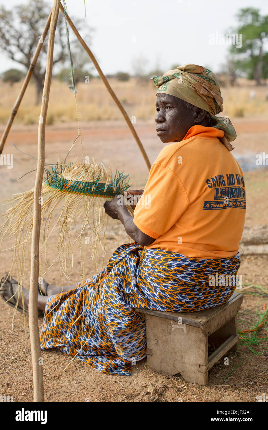 Les femmes d'une coopérative du tisserand traditionnel tisser des paniers de paille ensemble dans la région du nord-est, au Ghana. Banque D'Images