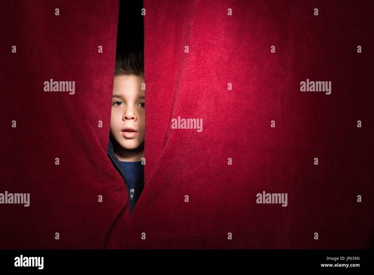 Enfant figurant sous le rideau Banque D'Images