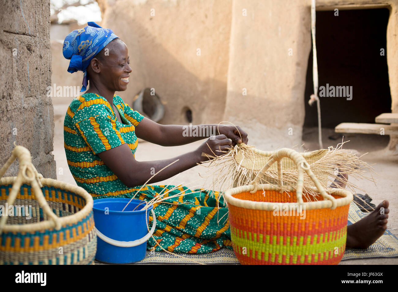 Une femme tisse des paniers de paille traditionnel dans la région du nord-est, au Ghana. Banque D'Images