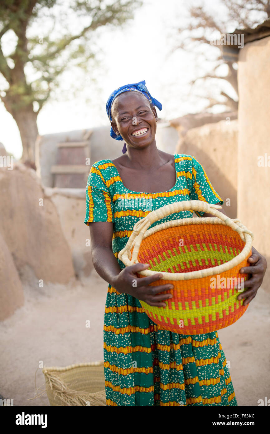 Une femme est titulaire d'un panier de paille traditionnel dans la région du nord-est, au Ghana. Banque D'Images