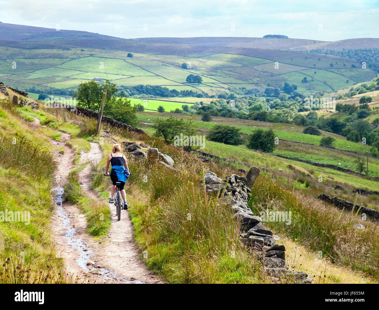 Une femme sur un vélo bridleway près de trois Shires Head dans le Peak District National Park Banque D'Images