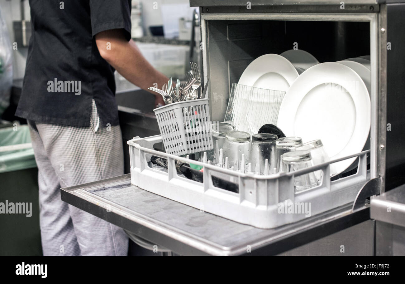 La cuisine ouverte avec un lave-vaisselle rempli de nettoyer les plaques blanches dans un restaurant cuisine dans un concept d'hygiène et de restauration Banque D'Images