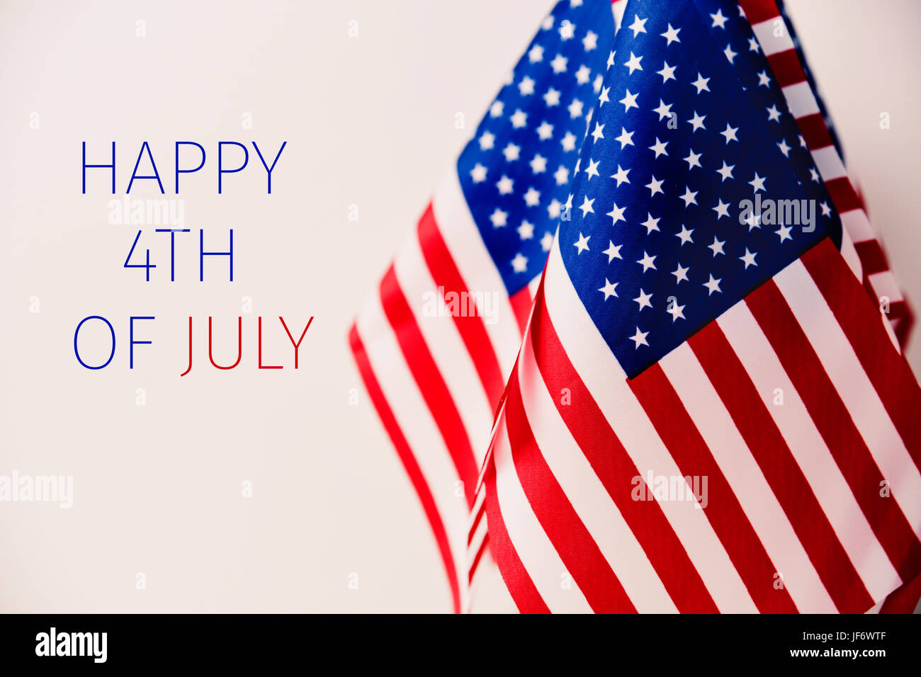 Quelques drapeaux américains et le texte heureux 4 juillet contre un fond blanc Banque D'Images
