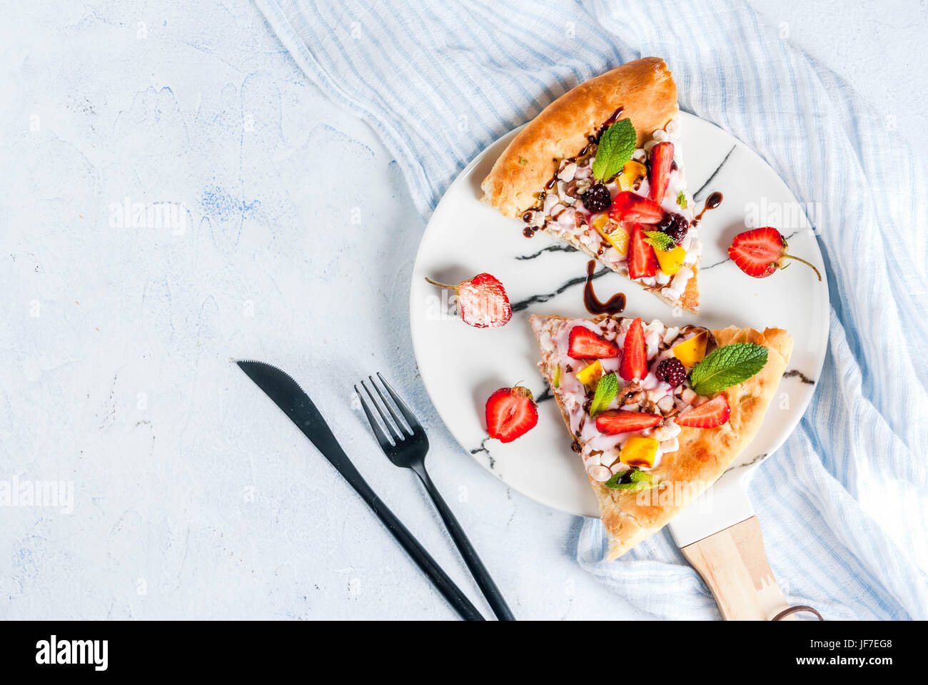 Des collations d'été. La nourriture pour partie. Pizza aux fruits avec de la crème, de cassis, de yaourts, de fraises, mangues, pêches, bananes, mûres, de chocolat, de noix, de la menthe Banque D'Images