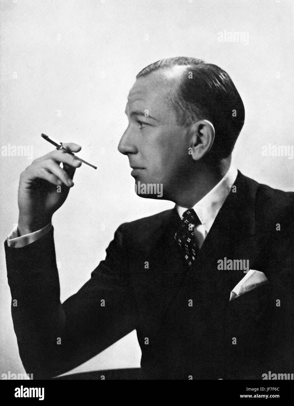 Noel Coward fumeurs profil avec un porte-cigarette, vers 1936. Acteur, dramaturge et compositeur : 16 décembre 1899 - 26 mars 1973. Banque D'Images