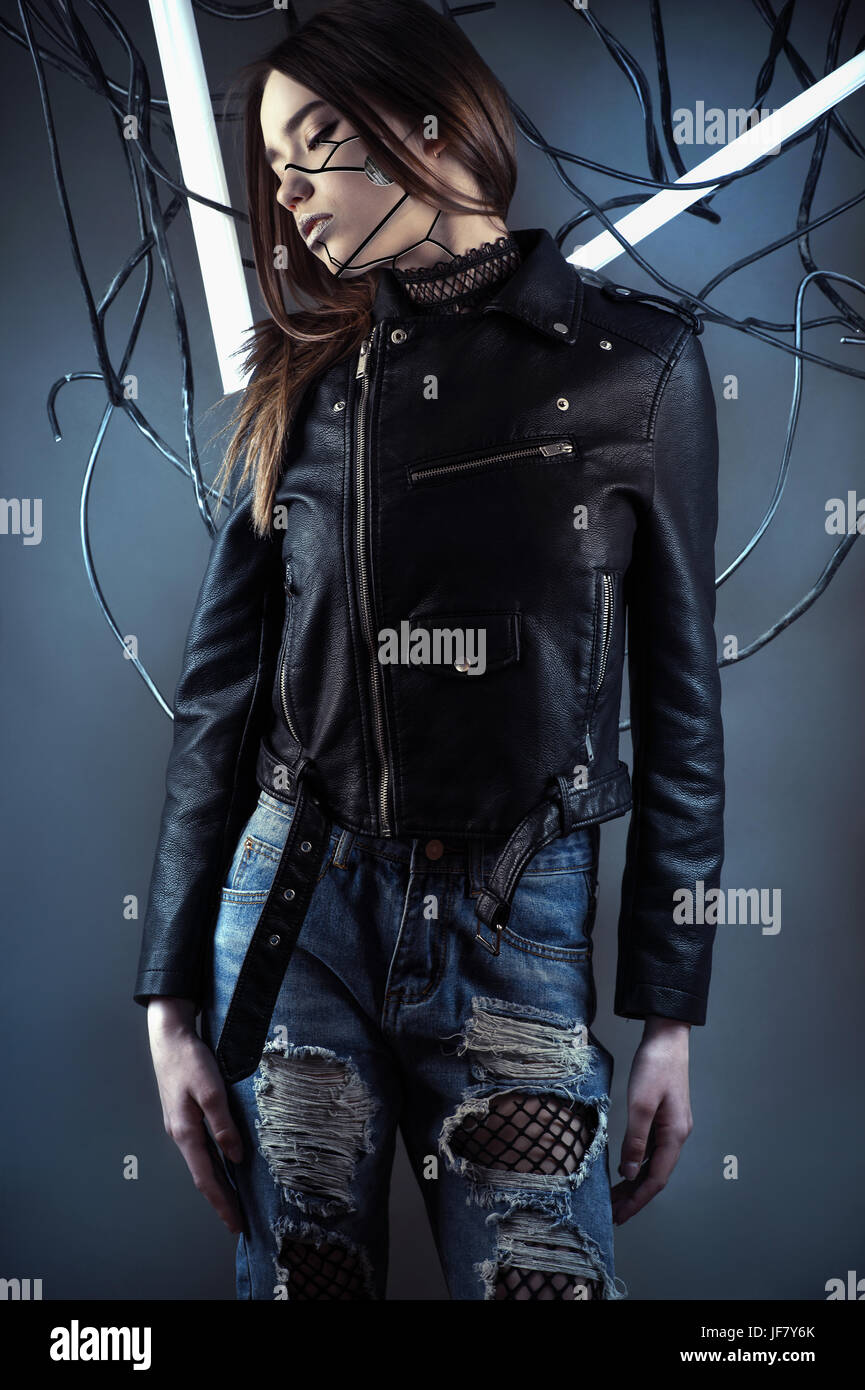 Robot girl élégante dans les fils dans le style cyberpunk en veste en cuir et des jeans déchirés Banque D'Images