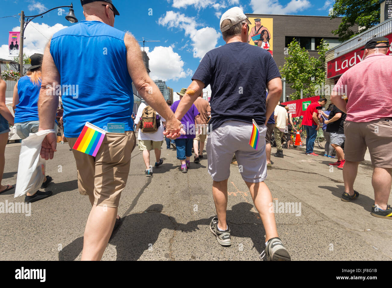 Toronto, CA - 24 juin 2017 : Gay couple holding hands and walking sur la rue de l'Église dans le Village gai. Banque D'Images