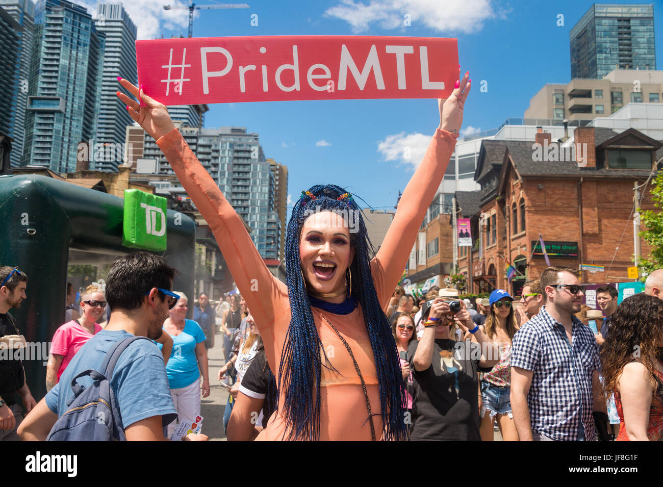 Toronto, Canada - 25 juin 2017 : drag queen avec un panneau promotion Montréal Gay Pride Parade durant la semaine à Toronto Banque D'Images