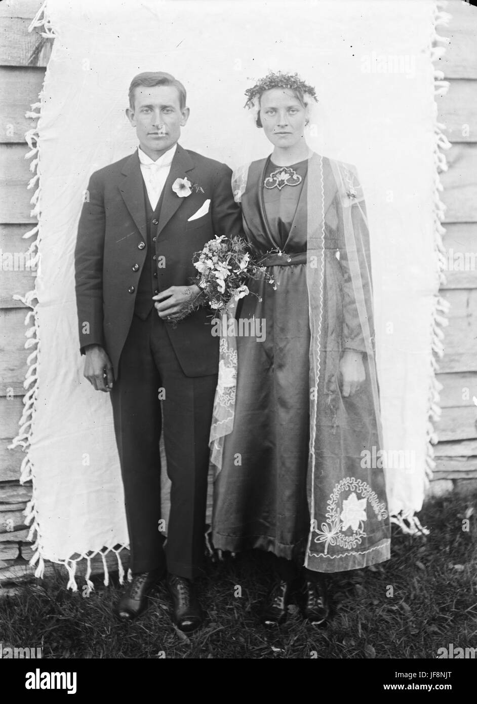 Photographie historique d'une mariée et d'un marié du début du XXe siècle, capturée lors de leur cérémonie de mariage, symbolisant l'amour, la tradition et les pratiques culturelles de l'époque. Banque D'Images