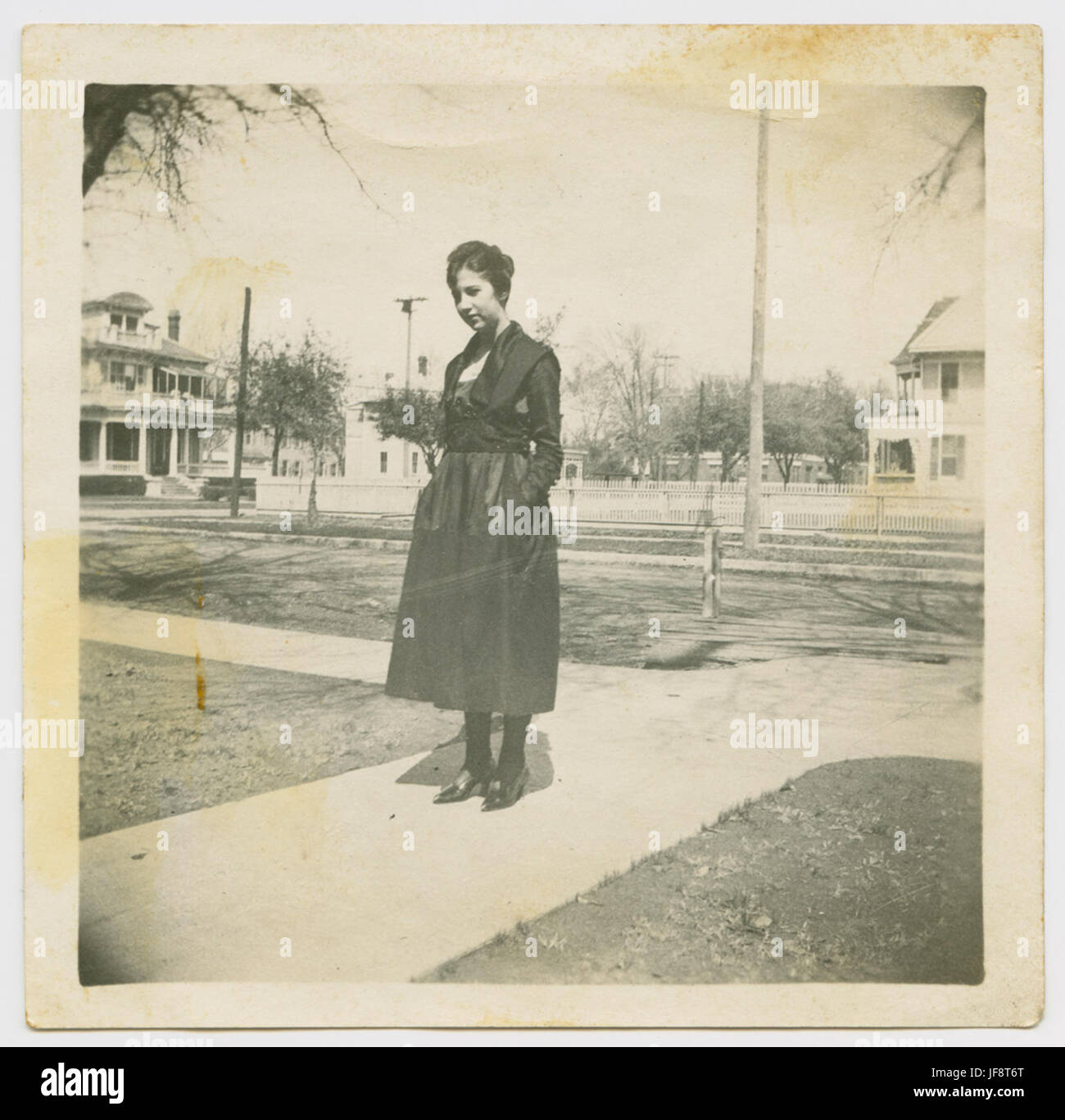 Portrait classique d'une femme vêtue d'une robe noire à Houston Heights, capturant la mode et l'élégance du début du XXe siècle. Banque D'Images