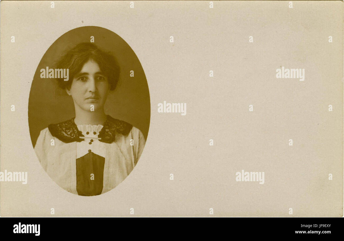 Portrait vintage d'une femme non identifiée, capturant l'essence de la mode du début du XXe siècle et des normes sociétales à travers son expression et sa tenue vestimentaire. Banque D'Images