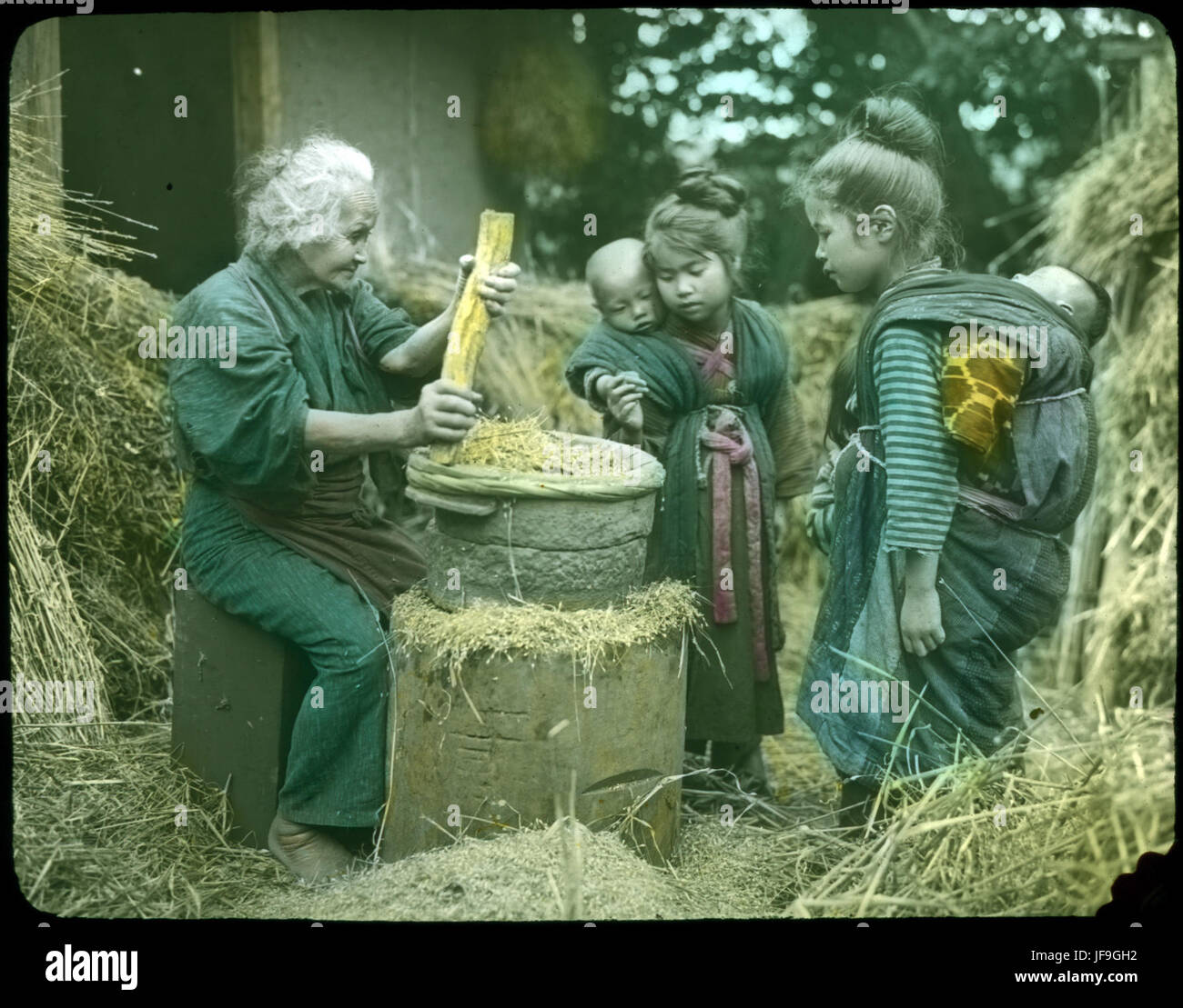 Une photographie historique touchante d'une femme âgée et de deux enfants dans un cadre rural Banque D'Images