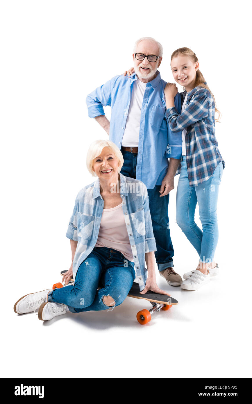 Grand-père, la grand-mère et petite-fille heureuse avec skateboard isolated on white Banque D'Images